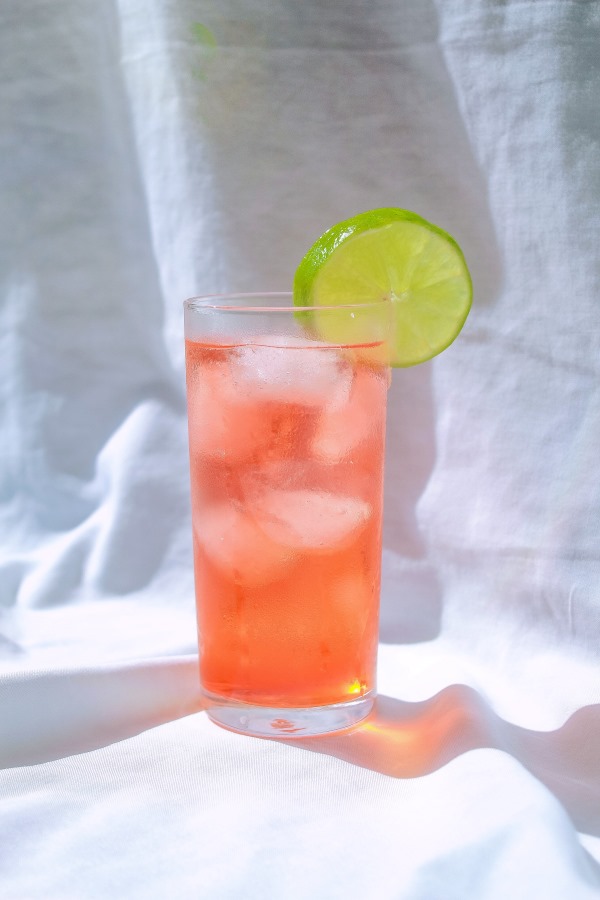 verre highball avec un cocktail cosmopolitan allongé à l'eau gazeuse