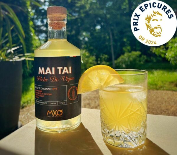 Cocktail Mai Tai à la pêche de vigne sur une table au soleil