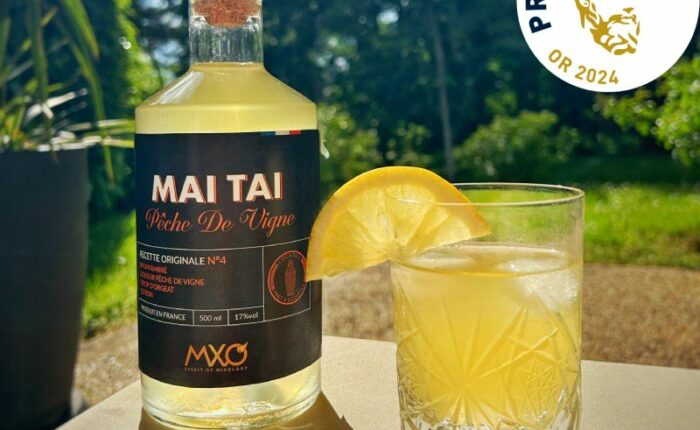 Cocktail Mai Tai à la pêche de vigne sur une table au soleil