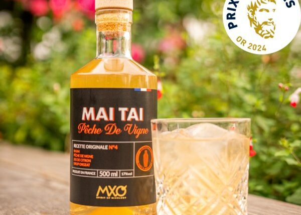 Cocktail Mai Tai à la pêche de vigne sur une table au soleil