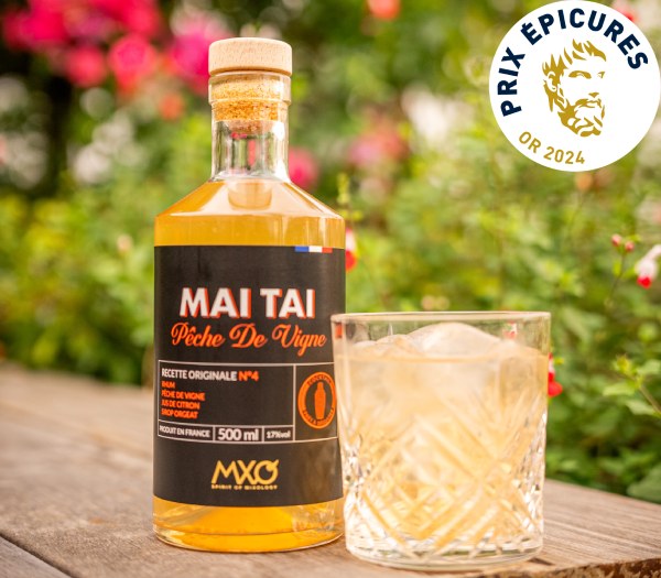 Cocktail Mai Tai à la pêche de vigne sur une table au soleil